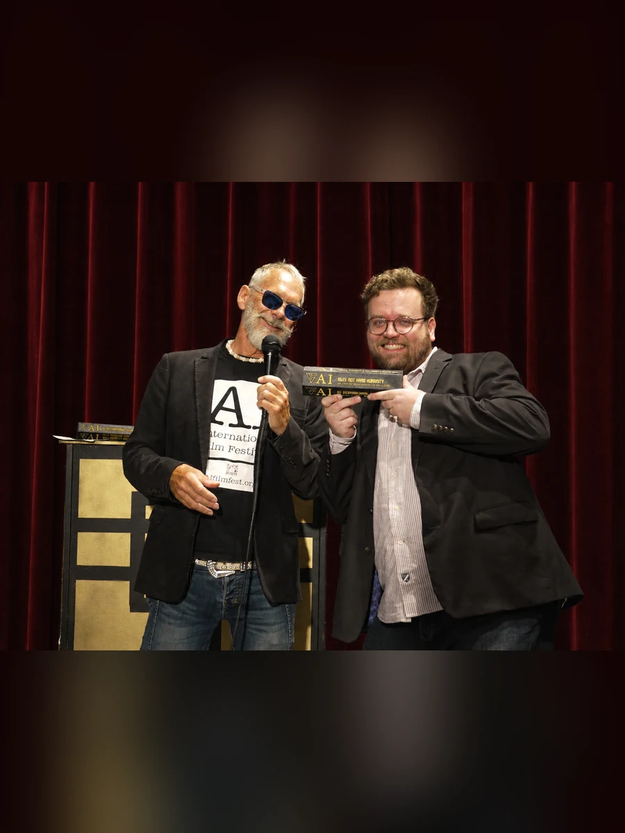 Bert Holland and Scott Newman on stage with an award